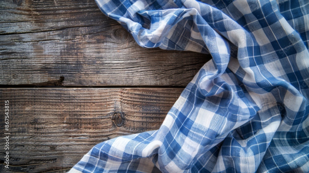 Blue and white checkered fabric on rustic wooden surface Blue and white checkered fabric on rustic wooden surface