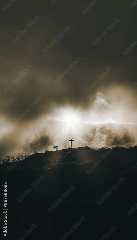 Fototapeta premium A crucifix stands atop a mountain as sunlight breaks through the clouds, creating an inspirational Christian scene. The image symbolizes faith, hope, and divine light