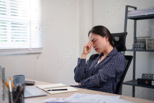 Businesswoman feeling exhausted and stressed from overworked while resting in modern office after working to analysis about investment of business project and strategy marketing of new business