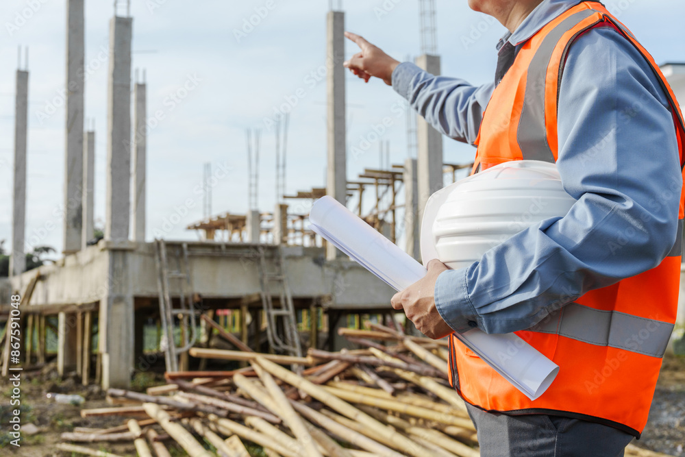 Male Asian construction contractor engineer checks structural plans, engineers concrete columns and beams of a new house. Male Asian construction contractor engineer checks structural plans, engineers concrete columns and beams of a new house.