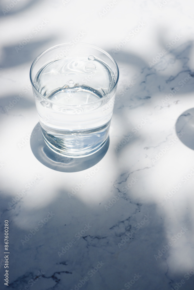 a glass of drinking water on white marble table. a glass of drinking water on white marble table.