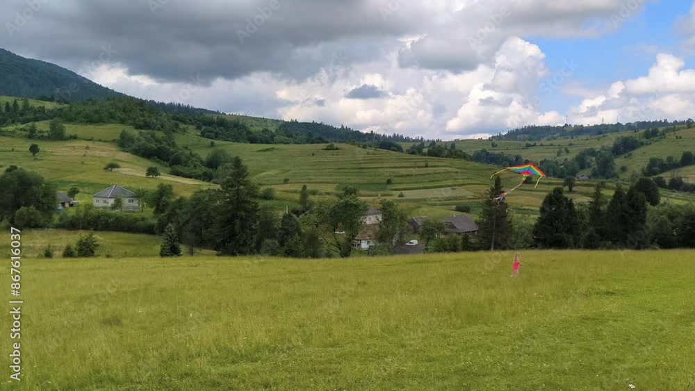 little girl with colorful striped kite in Carpathian mountains, horizontal footage little girl with colorful striped kite in Carpathian mountains, horizontal footage