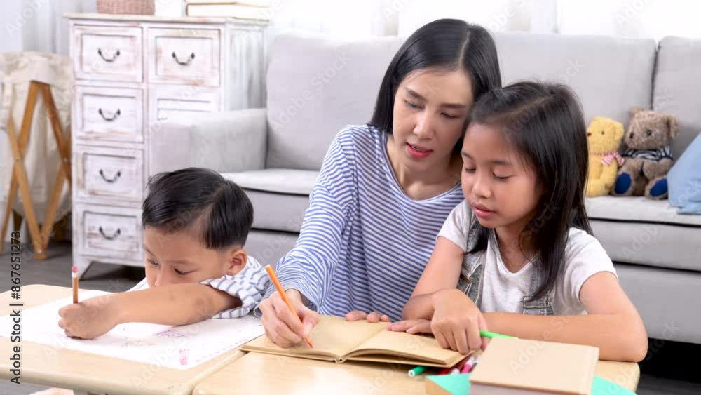 Cheerful Asian mother spend time with two sibling kids teaching homework drawing picture together in living room at home, free time children on holiday bonding happy relationship with mom parenthood Cheerful Asian mother spend time with two sibling kids teaching homework drawing picture together in living room at home, free time children on holiday bonding happy relationship with mom parenthood