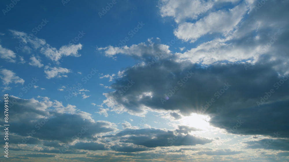 Obraz premium Majestic amazing sky. Sunburst or sun rays light beam through the clouds as fantastic background. Timelapse.