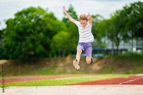 Foto Kids long jump athletics training. Child jumping.