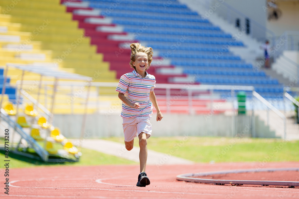 Fototapeta premium Child exercising. Kid running on stadium.