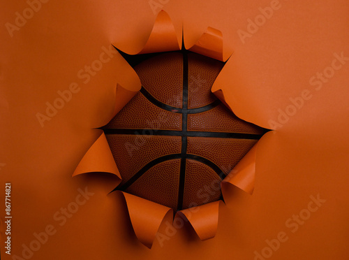 basketball breaking through orange background