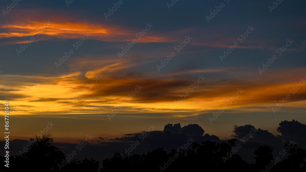 Silhouette of trees behind a beautiful golden sky at sunset, with the
back-light at the horizon transitioning from orange to shades of
golden clouds Silhouette of trees behind a beautiful golden sky at sunset, with the
back-light at the horizon transitioning from orange to shades of
golden clouds
