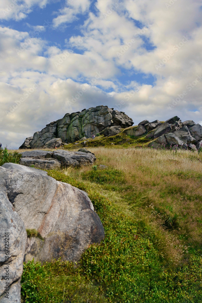 Grassland, eroded boulders, and rugged rock formations make up Almscliffe Crag in North Rigton, Yorkshire, UK. Grassland, eroded boulders, and rugged rock formations make up Almscliffe Crag in North Rigton, Yorkshire, UK.