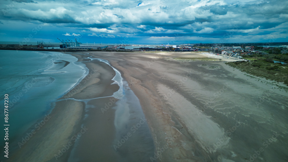 Mesmerizing aerial view of Dunkirk beach captured by a drone! The expansive golden sands and shimmering blue waters of the North Sea offer a breathtaking and tranquil scene, perfect for tourism, trave Mesmerizing aerial view of Dunkirk beach captured by a drone! The expansive golden sands and shimmering blue waters of the North Sea offer a breathtaking and tranquil scene, perfect for tourism, trave