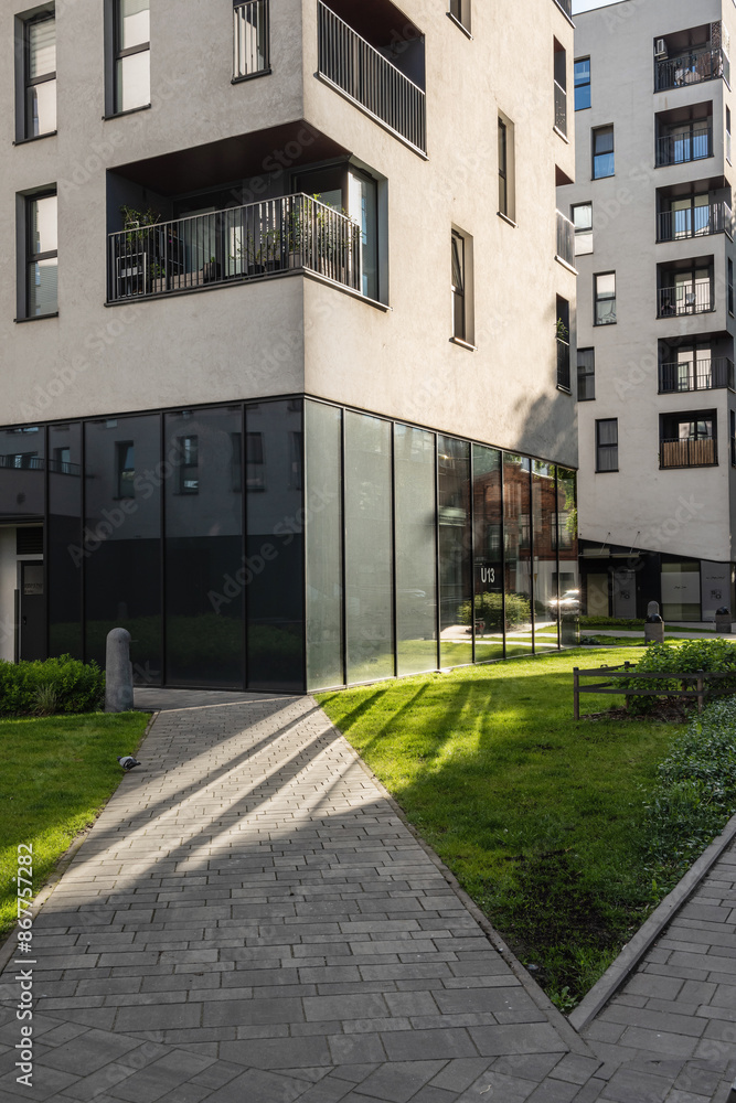 A fragment of a residential building and the surrounding area with landscaping A fragment of a residential building and the surrounding area with landscaping