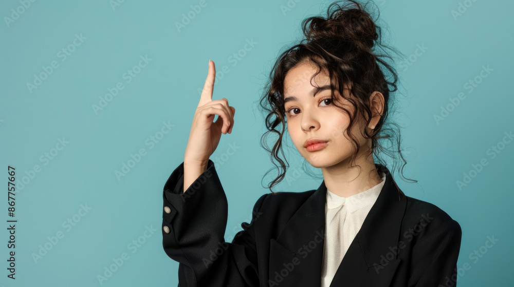 A Japanese businesswoman with curly hair points upward as she shares her latest idea