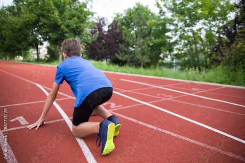 The athlete stands on the starting line on the track.