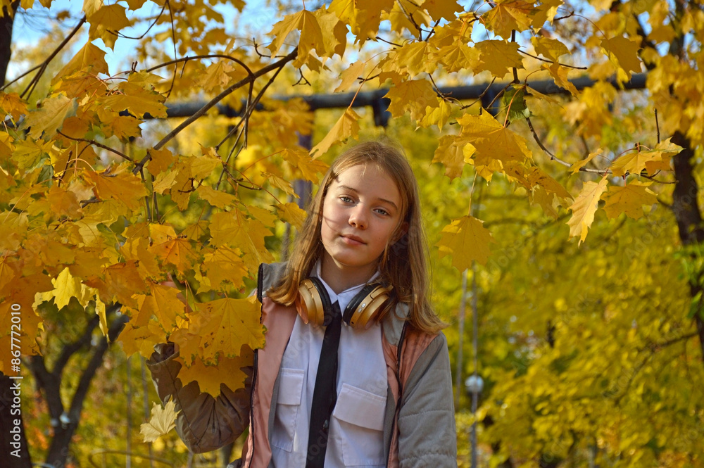 beautiful, cheerful girl on a walk in the autumn park. a child stands near a maple branch with yellow leaves enjoying the good weather, the beauty in nature and the warm autumn sun beautiful, cheerful girl on a walk in the autumn park. a child stands near a maple branch with yellow leaves enjoying the good weather, the beauty in nature and the warm autumn sun
