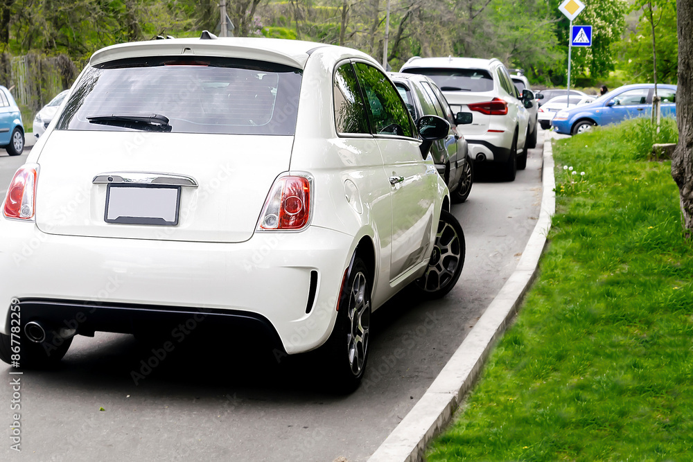 Long row of modern cars parking tightly along city road street. Urban transportation infrastructure,parking problems in residential district,technology.vehicles parked by curb Long row of modern cars parking tightly along city road street. Urban transportation infrastructure,parking problems in residential district,technology.vehicles parked by curb