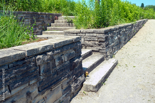 Luxury landscaping with natural stone retaining wall and coping, wide steps and landing.