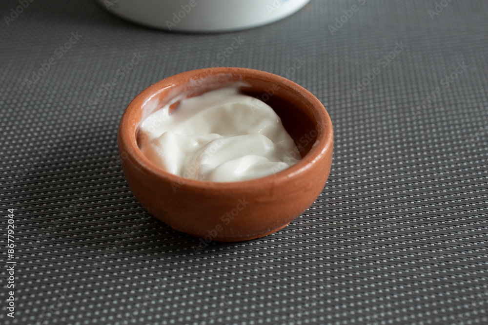 A closeup view of a clay condiment cup of dairy-free sour cream. A closeup view of a clay condiment cup of dairy-free sour cream.