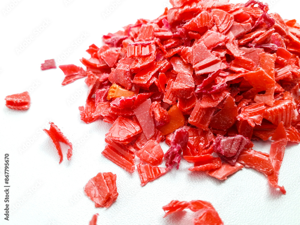 shredded red plastic waste ready for recycling, isolated on white background shredded red plastic waste ready for recycling, isolated on white background