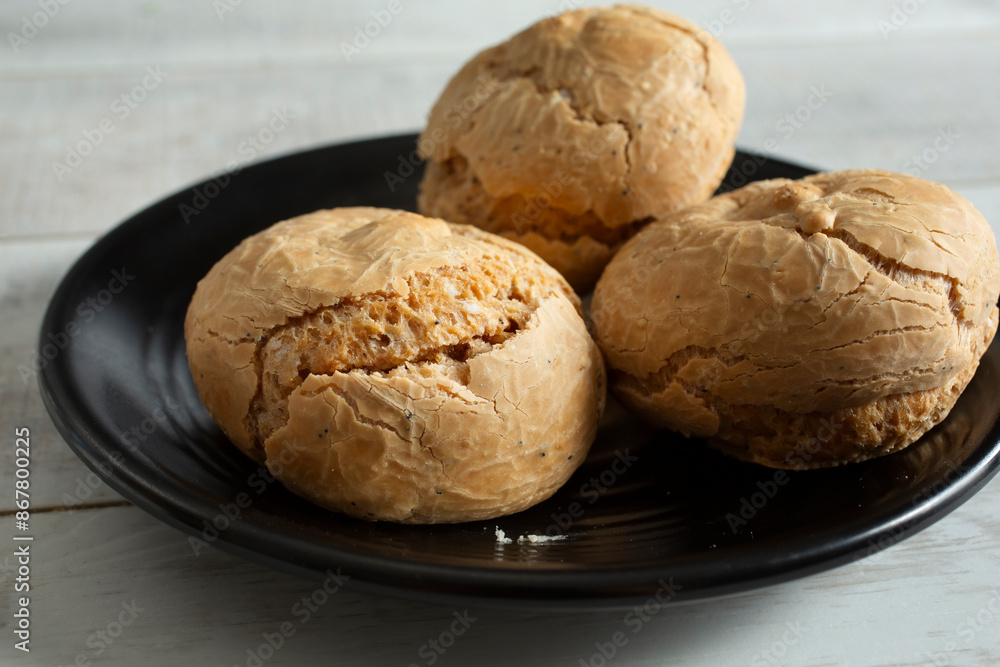 A view of gluten-free rolls on a black plate. A view of gluten-free rolls on a black plate.