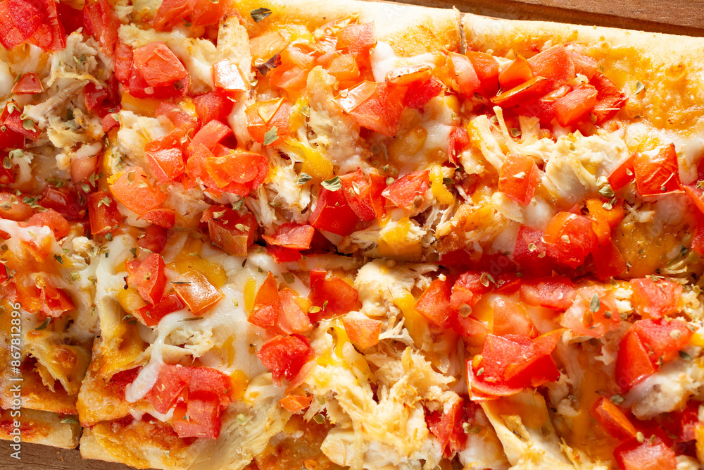A top down view of a flatbread appetizer, featuring toppings as chicken, tomato and cheese. A top down view of a flatbread appetizer, featuring toppings as chicken, tomato and cheese.