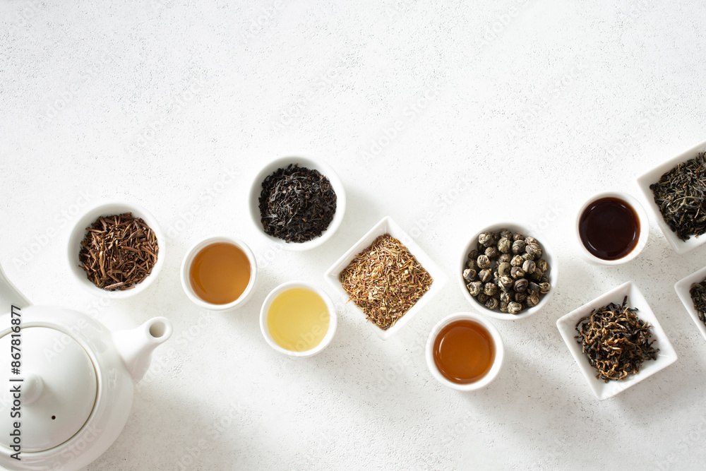 A top down view of assorted loose leaf tea and tea liquor, on the bottom of the frame. A top down view of assorted loose leaf tea and tea liquor, on the bottom of the frame.