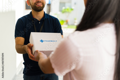 Closeup of a delivery man delivering medication in a white box with the word pharmacy on it to a woman