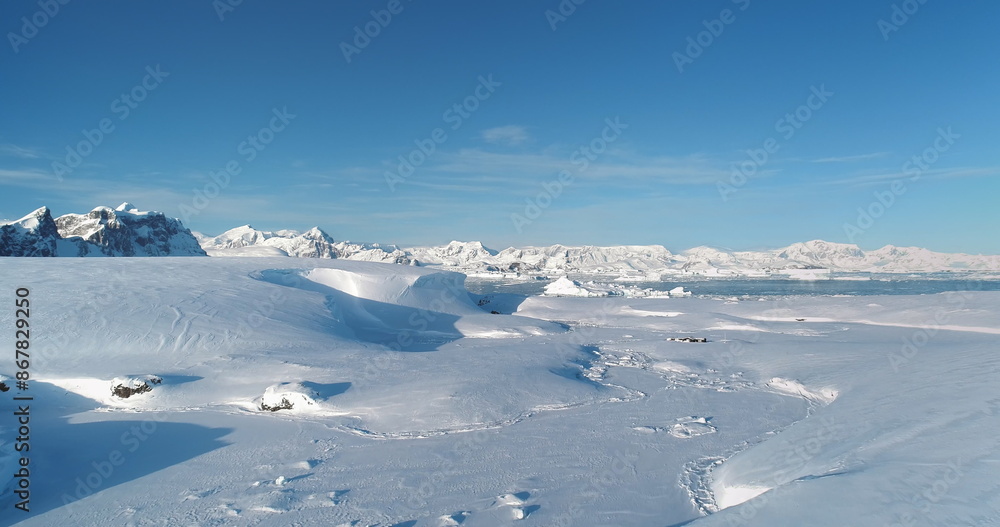 Snow covered Antarctica hills and mountains, frozen wild nature beauty. Snowy untouched landscape under blue sky sun. Majestic winter scene. South Pole perfect travel background. Aerial drone Snow covered Antarctica hills and mountains, frozen wild nature beauty. Snowy untouched landscape under blue sky sun. Majestic winter scene. South Pole perfect travel background. Aerial drone