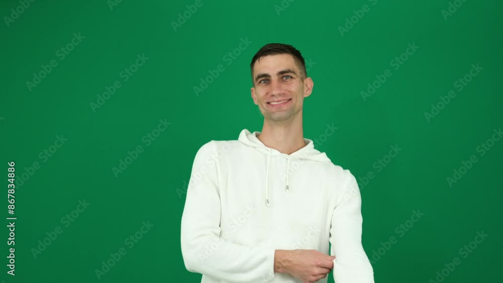 Roll up sleeves. man laughs sincerely, male looks into frame. emotions of handsome guy on green background chromakey close-up dark hair. young man Roll up sleeves. man laughs sincerely, male looks into frame. emotions of handsome guy on green background chromakey close-up dark hair. young man
