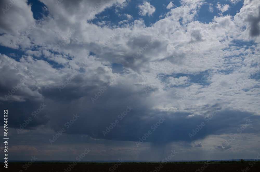 dark clouds with a gap of blue sky and white clouds