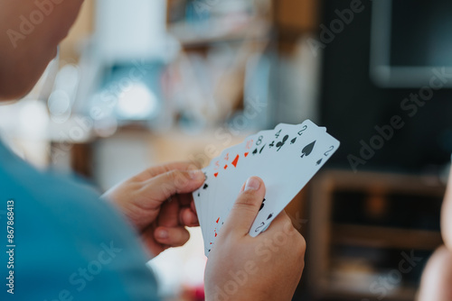 Foto Close-up of a person holding playing cards in hand, enjoying a card game at home during leisure time