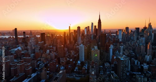 Sun sets above the modern metropolis. Golden hour in New York, United States from aerial perspective.