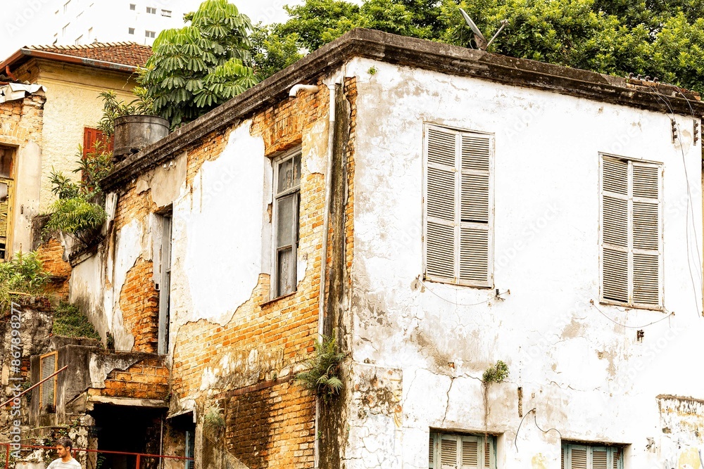 Casa velha com paredes descascadas e janelas de madeira quebradas. Casa velha com paredes descascadas e janelas de madeira quebradas.