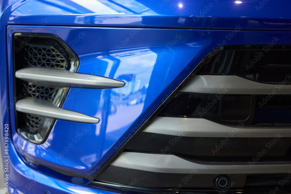 A detailed view of a contemporary car front grille with a stylish design and headlights A detailed view of a contemporary car front grille with a stylish design and headlights