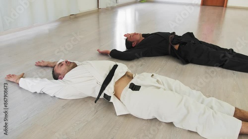 Men Are Lying On The Floor To Warm Up For Karate Session photo