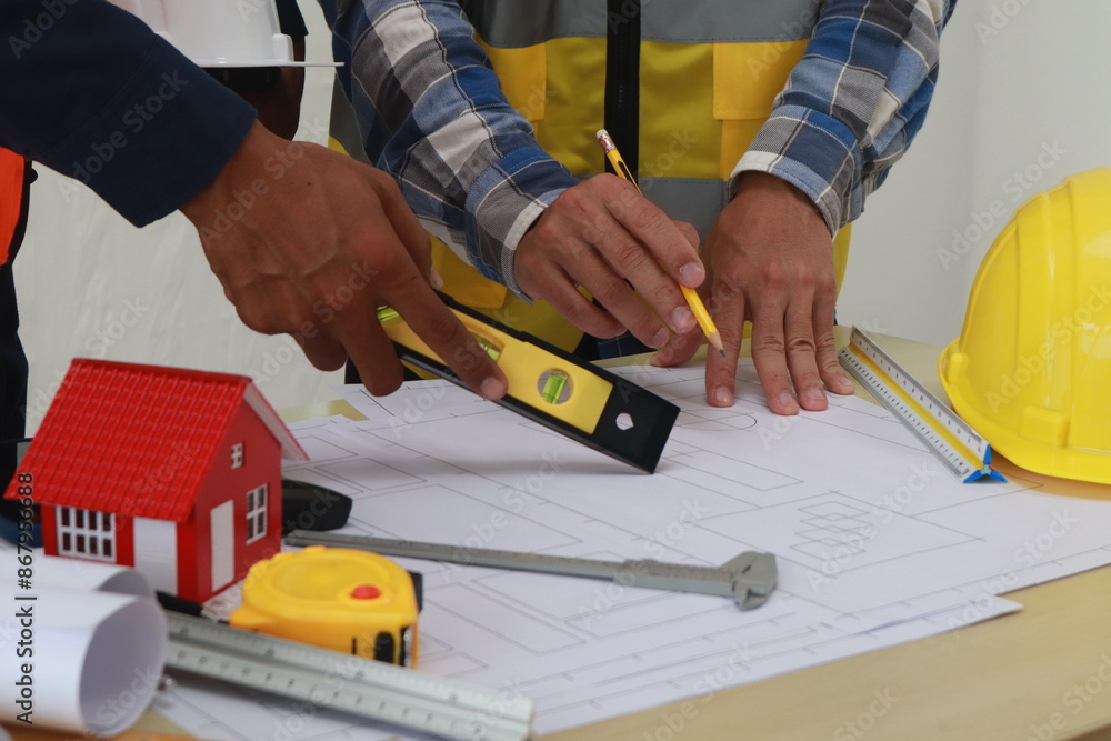 A team of engineers inspects beam work and installs concrete pillars according to the blueprint. A team of engineers inspects beam work and installs concrete pillars according to the blueprint.