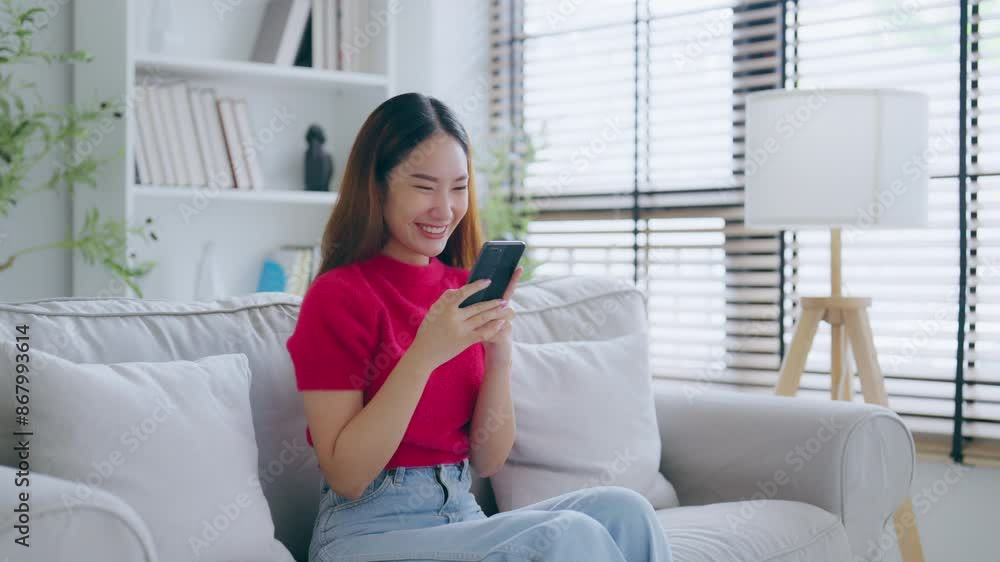 Happy young asian woman relax on comfortable couch at home texting messaging on smartphone, smiling girl use cellphone, chatting online message, shopping online from home Happy young asian woman relax on comfortable couch at home texting messaging on smartphone, smiling girl use cellphone, chatting online message, shopping online from home