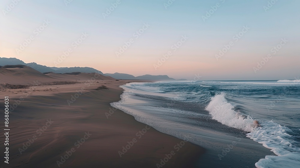 Fototapeta premium Peaceful morning on a deserted beach with soft waves and a clear sky transitioning from night to day