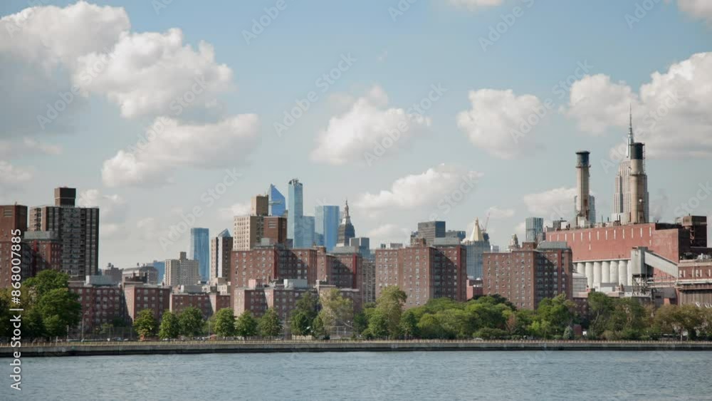 The dynamic Manhattan skyline with tall skyscrapers and industrial buildings captures the vibrant essence of a bustling city on a sunny day by the East River, showcasing a modern metropolis The dynamic Manhattan skyline with tall skyscrapers and industrial buildings captures the vibrant essence of a bustling city on a sunny day by the East River, showcasing a modern metropolis