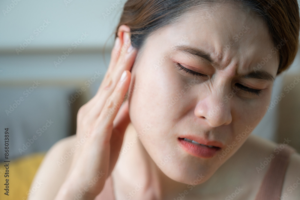 Asian woman having an earache problem. An earache is sharp, dull, or burning ear pain in one or both ears. Asian woman having an earache problem. An earache is sharp, dull, or burning ear pain in one or both ears.