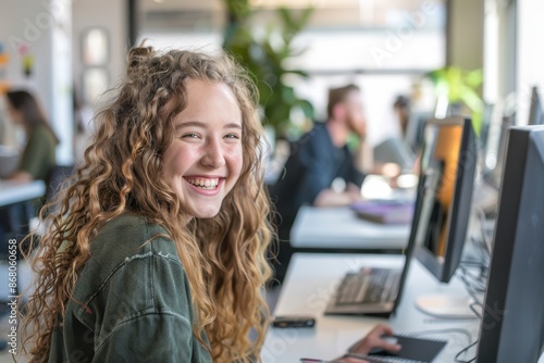 Smiling Woman Working at a Computer in a Modern Office