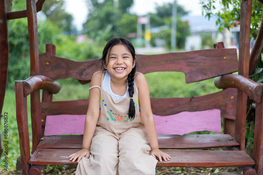 Φωτογραφία happy asian child laugh or kid girl smiling sitting rest relax on wooden swing o