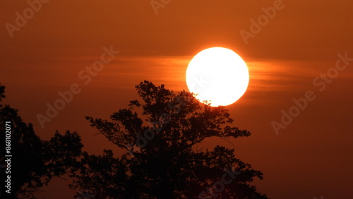 Φωτογραφία the sun at sunrise, with the large, glowing sun dominating the horizon