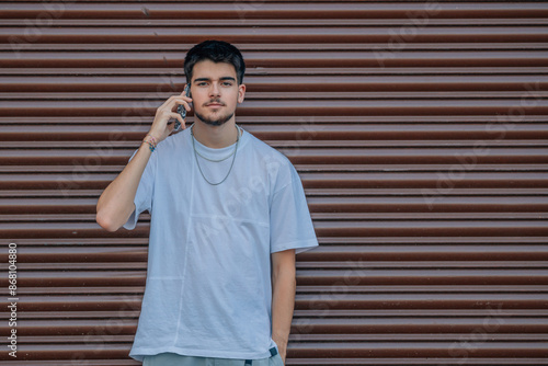 young student talking on mobile phone in the street