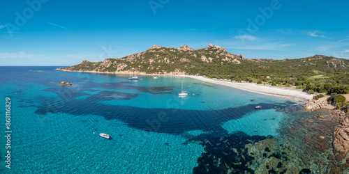 Panoramic aerial view of yachts at Roccapina beach on the Mediterranean coast of Corsica overlooked by the Genoese Tour de Roccapina and Lion of Roccapina, a rocky outcrop in the shape of a lion photo