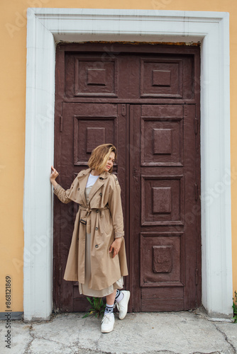 Wallpaper Mural Young millennial woman with wild hair dressed in an autumn coat posing near the door of an old building. Torontodigital.ca