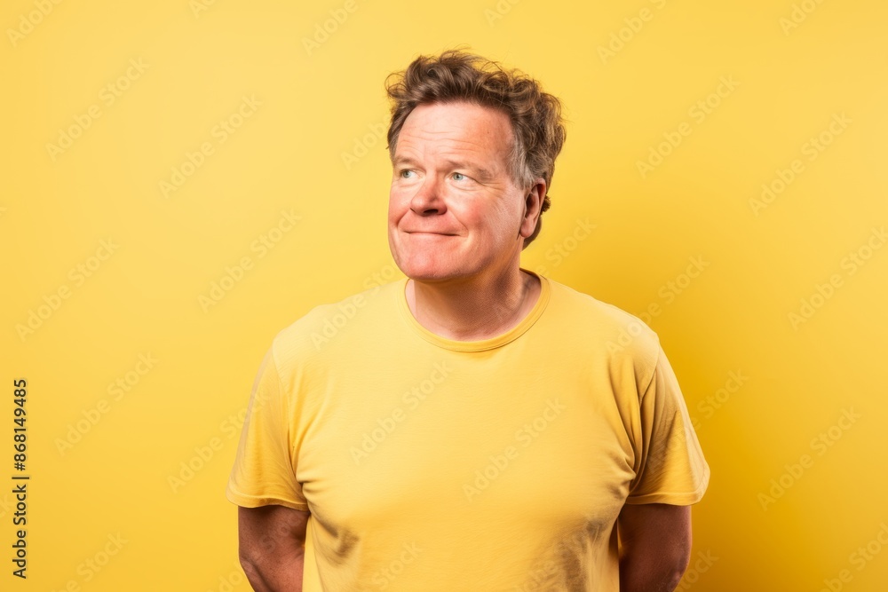 Middle age man with yellow t-shirt on a yellow background laughing Middle age man with yellow t-shirt on a yellow background laughing