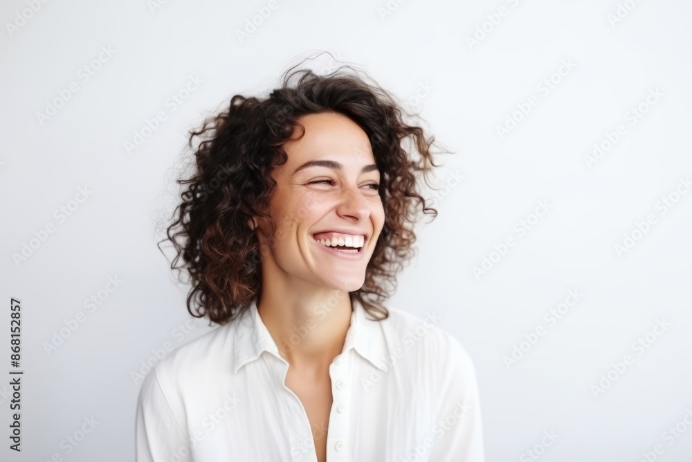 Portrait of a happy young woman with curly hair laughing against white background Portrait of a happy young woman with curly hair laughing against white background