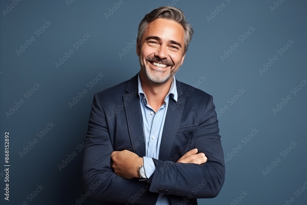 Portrait of a happy mature businessman with arms crossed against blue background. Portrait of a happy mature businessman with arms crossed against blue background.