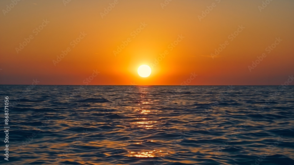A picture with a beautiful view of the sunset by the sea. The sky is completely orange, and the water is blue. The beauty of nature. Summer evening at the beach on holiday, vacation and travelling A picture with a beautiful view of the sunset by the sea. The sky is completely orange, and the water is blue. The beauty of nature. Summer evening at the beach on holiday, vacation and travelling