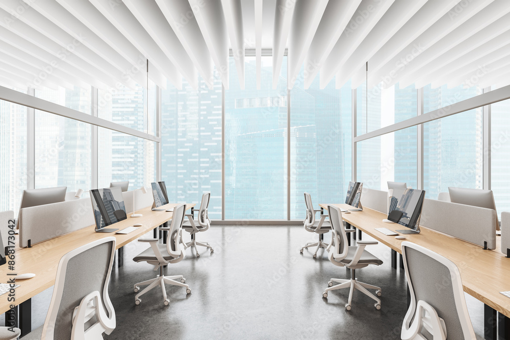 Cozy coworking interior with pc desktop in row, panoramic window Cozy coworking interior with pc desktop in row, panoramic window